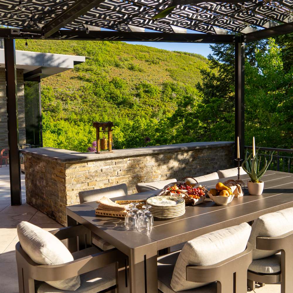 A large, bright bathroom is finished with marble countertops and walls and brushed stainless steel fittings.